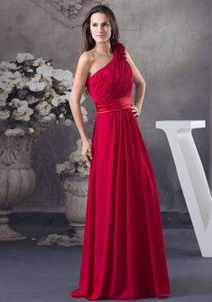 a woman in a long red dress posing for the camera with her hands on her hips