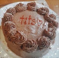 a chocolate frosted cake with the word itsy written in red icing on top