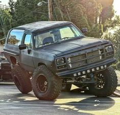 an off - road truck is parked in a parking lot