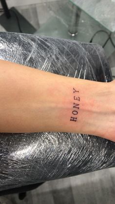 a woman's arm with the word honey tattooed on her left wrist and foot