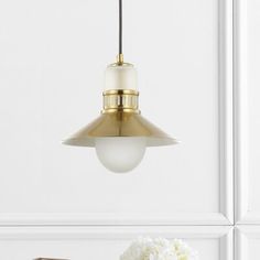 a white vase filled with flowers sitting on top of a table next to a lamp