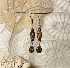 Pretty dangle earrings made from vintage beads and unique glass beads. Hooks are sterling silver. Nickel-free Brown Beaded Earrings With Czech Glass, Brown Czech Glass Beaded Drop Earrings, Nickel-free Brown Czech Glass Beaded Earrings, Brown Czech Glass Earrings With Dangling Beads, Artisan Czech Glass Beaded Round Earrings, Artisan Czech Glass Round Bead Earrings, Vintage Beaded Earrings With Ear Wire As Gift, Handmade Vintage Beaded Earrings With Round Beads, Artisan Czech Glass Beaded Earrings Nickel Free