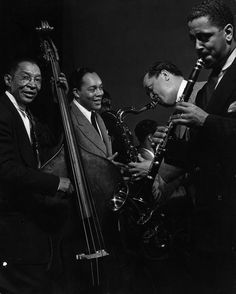 three men in suits and ties are playing instruments