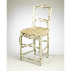 an old white chair with a wicker seat and back rest is shown in front of a plain background