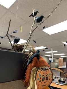 an office cubicle decorated for halloween with pumpkins and black birds on the branches