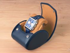 "This is the original watch roll with slide-in system, invented and designed by Carapaz in Switzerland. Unlike some cheaper imitations using our system, we do not produce in Asia and use only quality materials, such as full grain leather. We also do not copy anyone else's designs. TRAVEL WATCH CASE FOR 1 WATCH - WITH STAND FUNCTION - COMES IN GIFT BOX Color: NAVY BLUE with tan interior This is our brand-new watch case design, featuring a stand function. It lets the watch being displayed upright Rectangular Chronograph Watch Accessories For Business, Blue Rectangular Business Watches, Classic Blue Rectangular Watch Accessories, Blue Watch Accessories For Gift, Rectangular Blue Watch Accessories For Gift, Leather Watch Box, Watch Roll, Travel Storage, Case Design