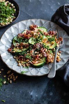 a white plate topped with cucumbers and other food on top of a table