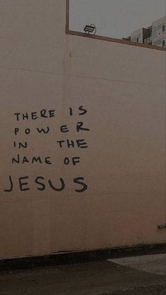 there is power in the name of jesus spray painted on a wall near a fire hydrant