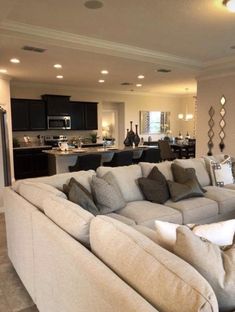 a living room filled with furniture next to a kitchen and dining room table in the background