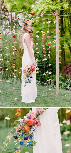 a woman in a white dress standing next to a wooden structure with flowers hanging from it