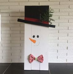 a wooden sign with a snowman wearing a hat and bow tie