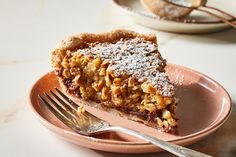 a piece of pie sitting on top of a pink plate with a fork next to it