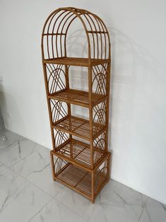 a bamboo birdcage on display in a white room