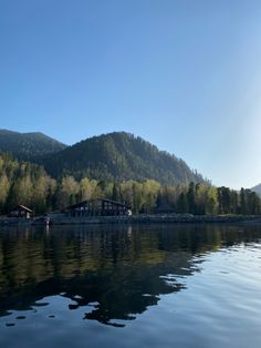 the water is calm and clear with houses in the background