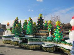 a parade float decorated with christmas trees and snowmen