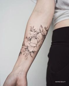 a woman's arm with a flower tattoo on the left side of her arm