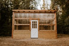 a small wooden building with a white door