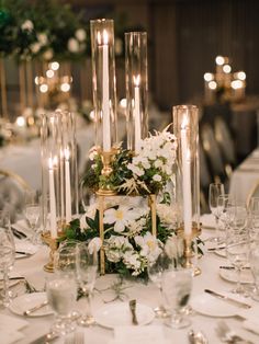 a table topped with lots of white flowers and candles