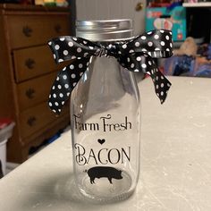 a glass jar with a black and white polka dot bow on the top that says farm fresh bacon