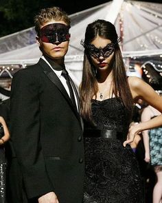 a man and woman dressed up in masquerades at an outdoor event together