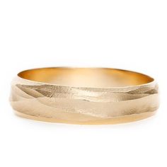 a gold wedding band with waves on it