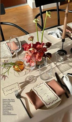 the table is set with flowers and place settings