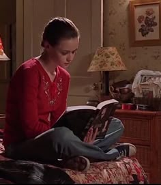 a woman sitting on a bed reading a book