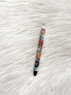 a pen with flowers on it sitting on top of a white fur