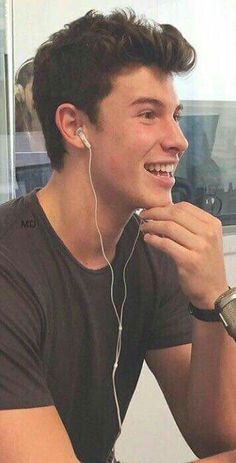 a young man sitting at a table with headphones on