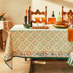 a table with bread, wine and candles on it in the middle of a room