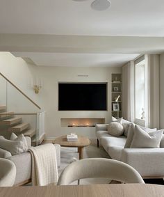 a living room filled with furniture and a flat screen tv mounted to the wall over a fireplace