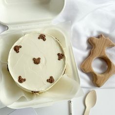 a cake in a box on a table with spoons and utensils next to it