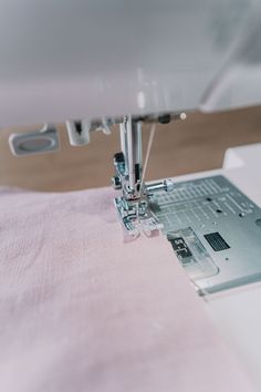 the sewing machine is being used to sew something on it's side,