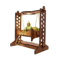 an ornate wooden swing with a buddha statue in the middle and gold decorations on it