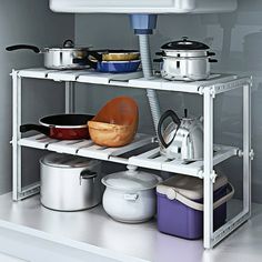 a kitchen shelf with pots and pans on it