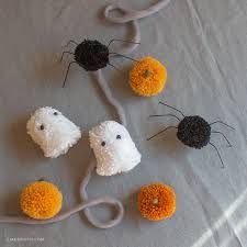 crocheted halloween decorations are arranged on a bed sheet with twine spools