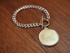 a coin on a metal chain sitting on a wooden table