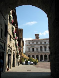 an archway leading to a building with flowers on it