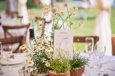 the table is set up with flowers and wine glasses for guests to sit down at