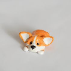 a small orange and white stuffed animal laying down