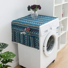 a white washer sitting next to a dryer on top of a wooden floor