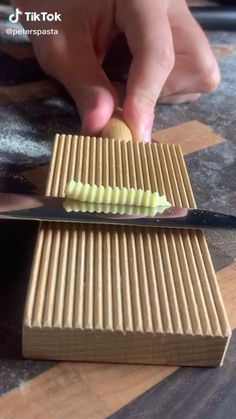 a person is cutting something with a knife on top of some cardboard boxes that are sitting on a table