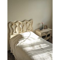 a white bed sitting next to a wall