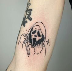 a black and white tattoo of a skull with a knife in it's hand