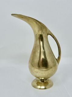 a gold colored vase sitting on top of a white table