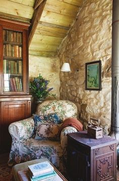 a living room filled with furniture next to a stone wall