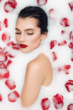 a woman in a bathtub with rose petals around her