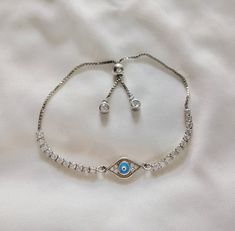 𝑯𝒂𝒏𝒅𝒎𝒂𝒅𝒆 𝒂𝒏𝒅 𝑴𝒊𝒏𝒊𝒎𝒂𝒍: Introducing our modern style Evil Eye bolo bracelet, perfect for those seeking unique and personalized jewelry. It features evil eye with cz stones in silver adjustable bracelet. #Mothers Day Gift DETAILS: * Evil Eye Bolo Bracelet * Comfortable & Lightweight * Delicate and Minimalist Design, Perfect for Everyday Wear * Perfect for holiday/ occasion wear * Makes a Wonderful Gift for Women and Girls * Mother's Day Gift ♥️Mother's Day Sale is ON > For US - Or Silver Adjustable Chain Bracelet Gift, Silver Adjustable Chain Bracelet As Gift, Adjustable Metal Bracelet As A Gift For Her, Adjustable Metal Bracelets As A Gift For Her, Silver Evil Eye Bangle Bracelet For Gift, Silver Evil Eye Bangle Bracelet Gift, Silver Adjustable Beaded Bracelets For Gift, Adjustable Silver Evil Eye Bracelet Gift, Elegant Adjustable Evil Eye Bracelet Gift