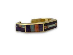 A modern take on a Western classic. Ben Nighthorse delicately inlaid this Sugilite, Pink Coral, Opal and Charoite cuff. 18kt (approx. 3.75 ounces) yellow gold. 1/2” wide. Other sizes are available as special orders - price quoted upon request. Call 970-247-3555 Luxury Gold Cuff Bracelet With Multi-stones, Luxury Gold Multi-stone Cuff Bracelet, Formal Bangle Bracelets With Inlay, Formal Bangle Bracelet With Inlay, Luxury Gold Jewelry With Inlay, Elegant Inlay Cuff Bracelet Bangle, Gold Multi-stone Cuff Bracelet As Gift, Gold Multi-stone Cuff Bracelet For Gift, Modern Gold Bracelet With Multi-stone