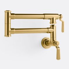 the brass faucet is attached to the wall and has two handles on each side